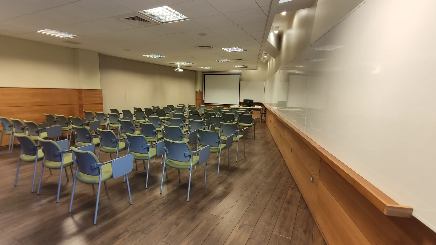 Sala de reunión equipada con proyector para eventos corporativos y clases en Espacios PUCV Santiago, Providencia