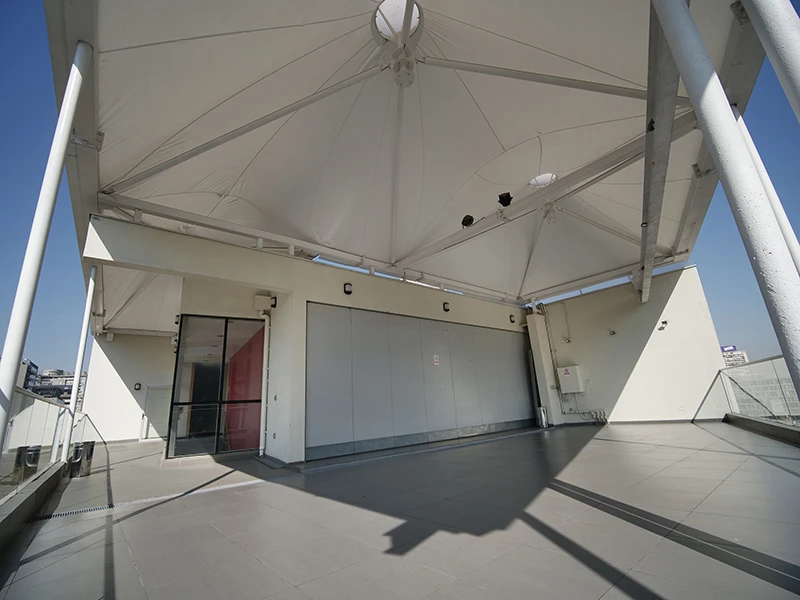 Terraza techada exterior con cubierta tensada en Espacios PUCV Santiago, Providencia
